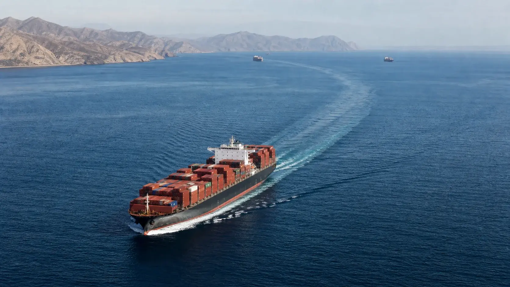 Commercial container ship navigating a narrow maritime corridor